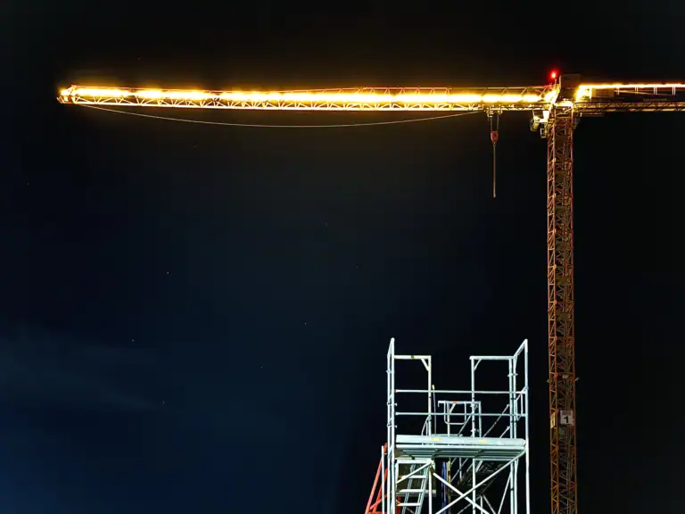 Dieses Titelbild von webpixelkonsum befindet sich bei Seiten und Blogartikel zum Thema Social-Media-Management für B2B-Unternehmen. Auf diesem Bild ist eine Baustelle bei Nacht zu sehen. Zusätzlich zeigt dieses Bild einen beleuchtenden Kran mit einem Bruchteil von einem Gerüst. Damit bezieht sich dieses Titelbild auf die Bauwirtschaft, Baugewerbe beziehungsweise Baubranche.